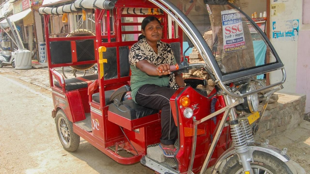 An e-rickshaw driver with SMV Green Solutions poses for a photograph. Credit: PTI