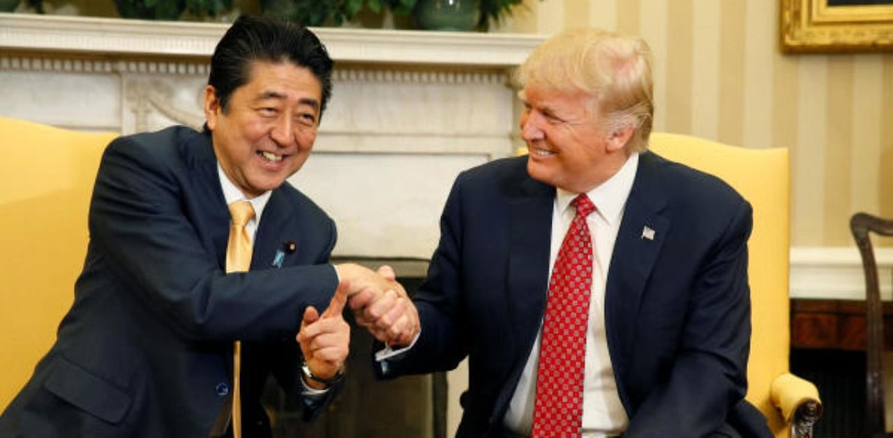 Japanese Prime Minister Abe shakes hands with US President Trump during their meeting in the Oval Office at the White House in Washington. Credit: Reuters