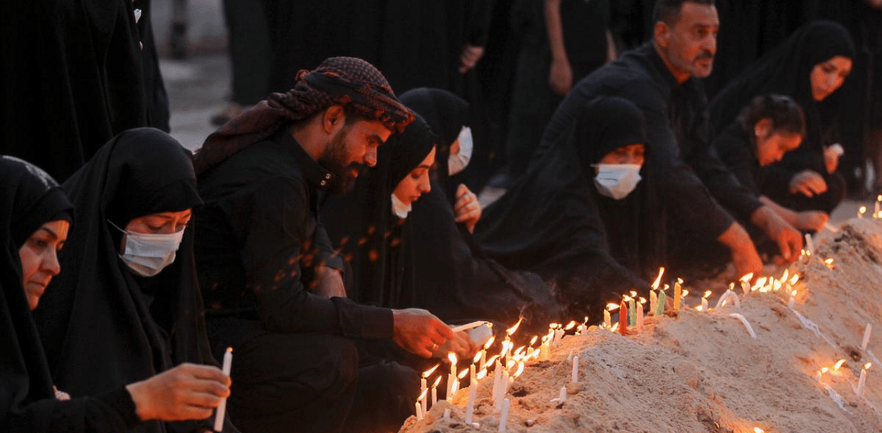 An Iraqi woman reads verses from the Koran on the tenth day of the month of Muharram which marks the peak of Ashura, in the holy city of Karbala, on August 30, 2020. Credit: AFP