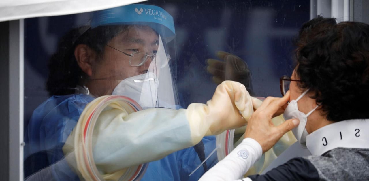 A woman undergoes a coronavirus disease (Covid-19) test at a makeshift clinic in Seoul, South Korea. Credits: Reuters