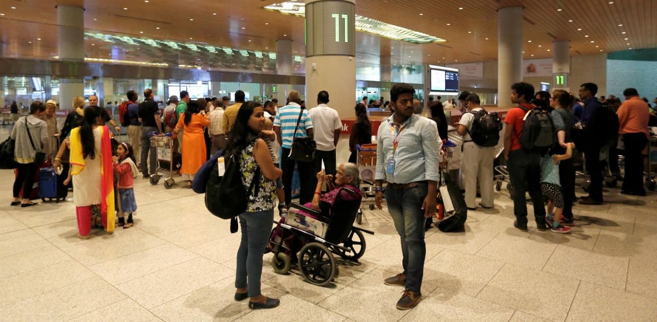 Passengers wait for their luggage at a conveyor belt at the Chhatrapati Shivaji International airport in Mumbai. Credits: Reuters