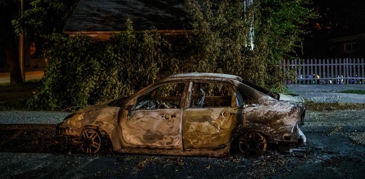 The carcass of a car burnt by protestors. Credits: AFP