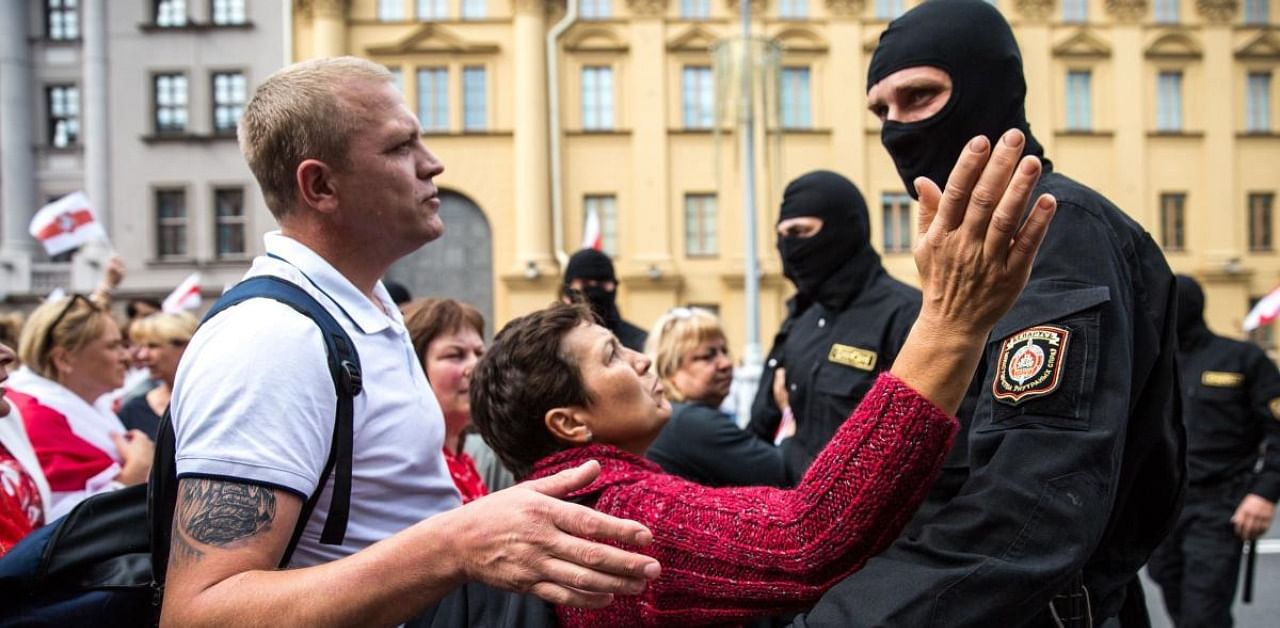 Protesters speak with Belarusian special police officers while opposition supporters rally to protest against disputed presidential elections results in Minsk. Credits: AFP