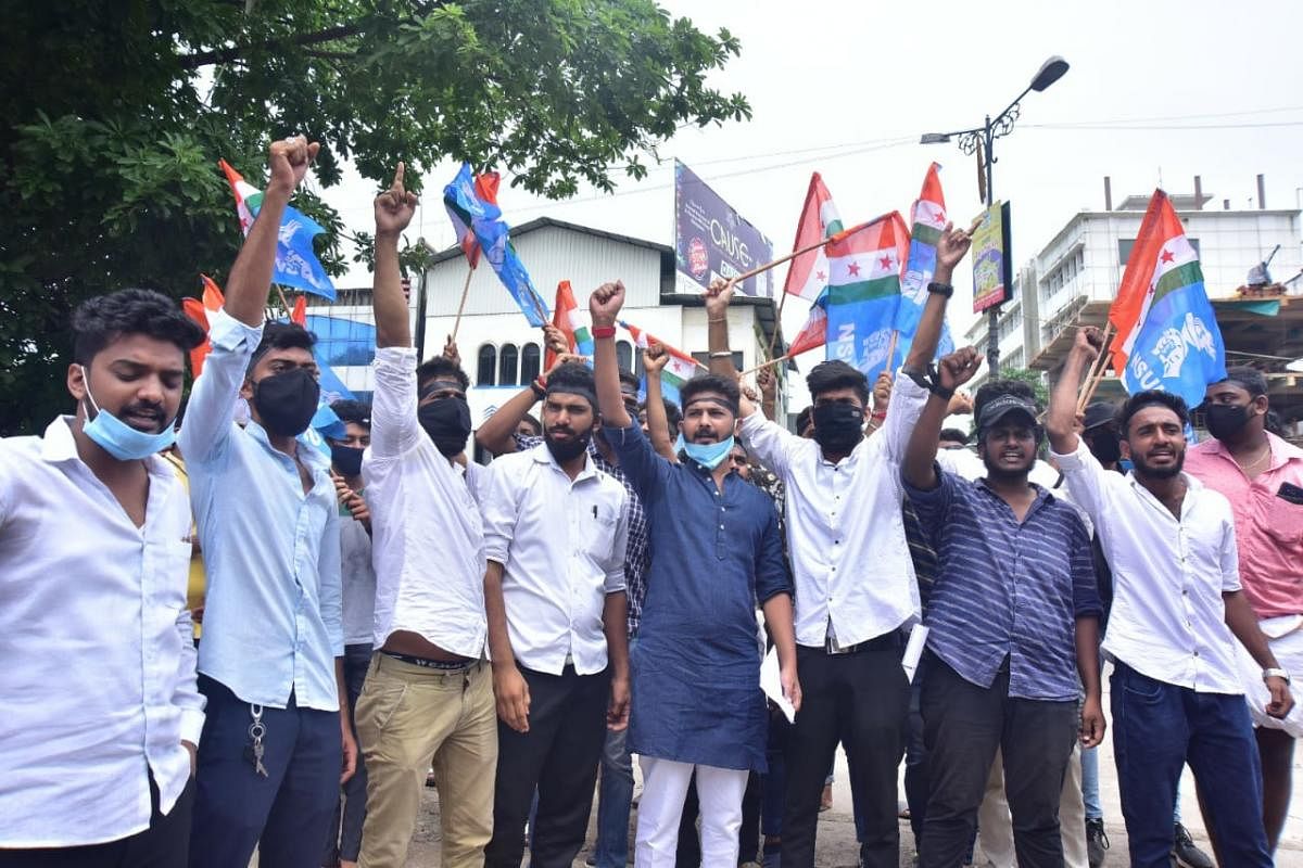 NSUI members stage a protest in front of University College in Mangaluru on Monday.