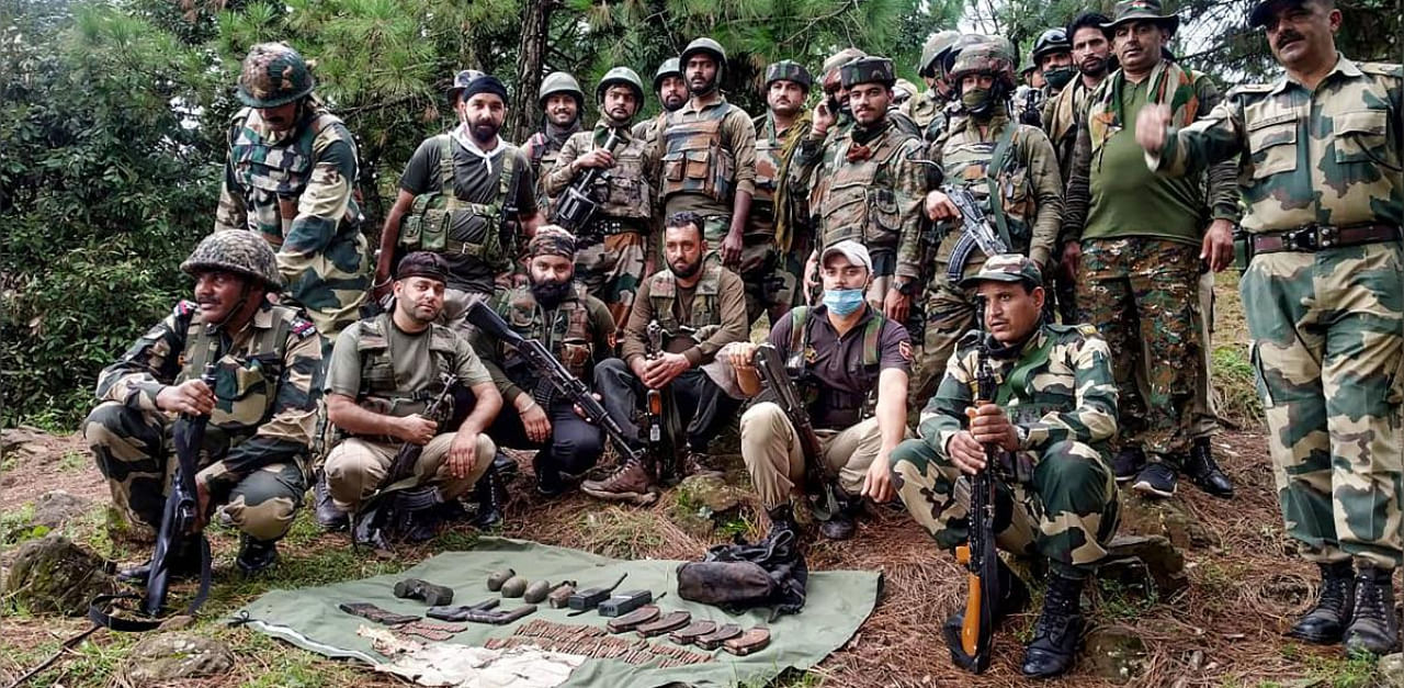 Security forces personnel pose for a group photo after busting a militant hideout and recovering arms ammunition in Khanater Top area of Poonch district. Credit: PTI