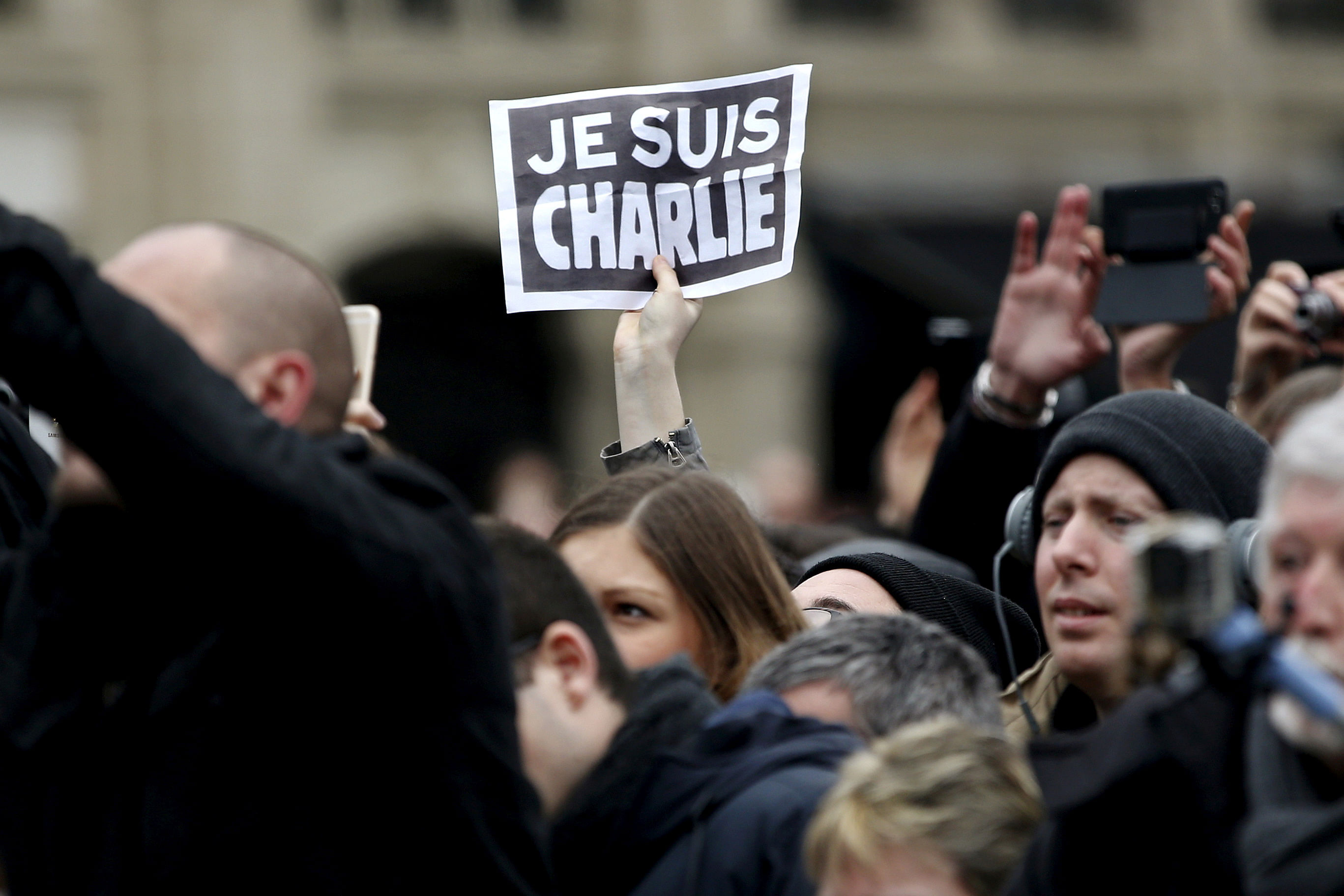 A person holds up a "Je Suis Charlie" (I am Charlie) sign during a ceremony at Place de la Republique to pay tribute to the victims of last year's shooting at the French satirical newspaper Charlie Hebdo. Credit: Reuters