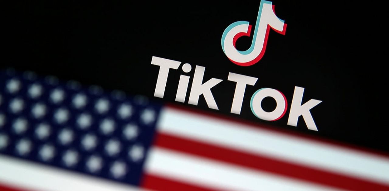 A US flag is displayed in front of Tik Tok logo. Credits: Reuters