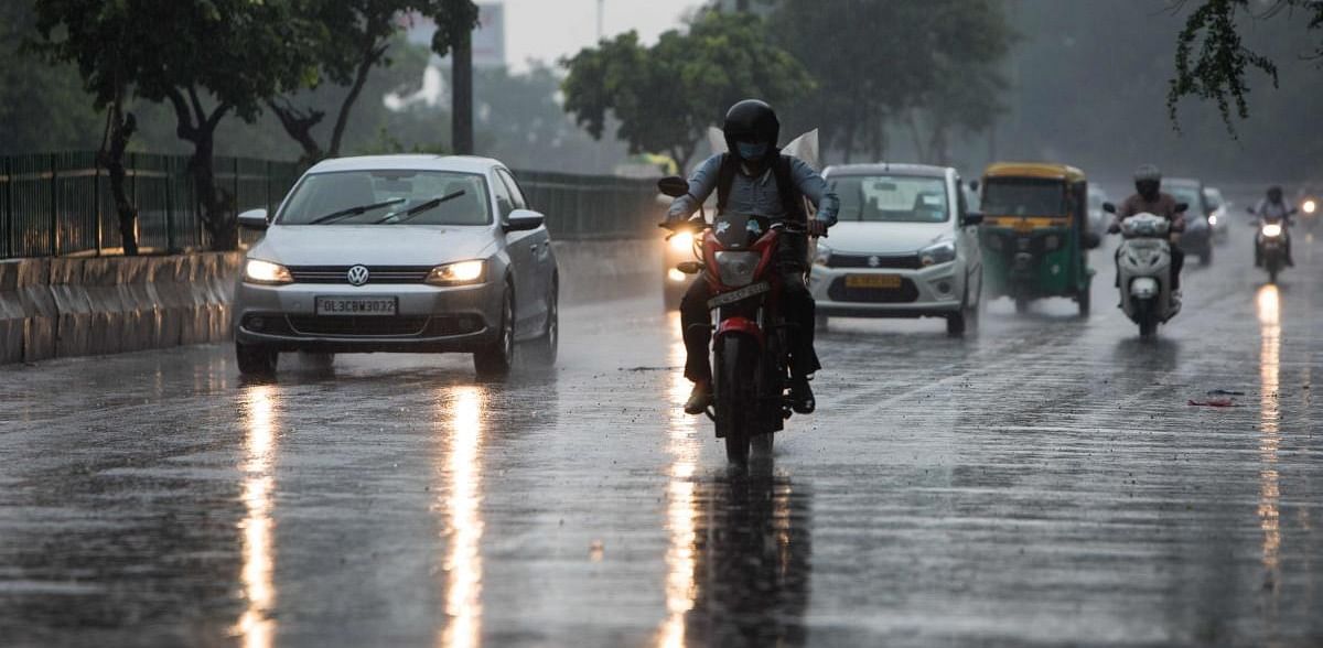 Commuters drive along a road during a monsoon rainfall in New Delhi. Credits: AFP