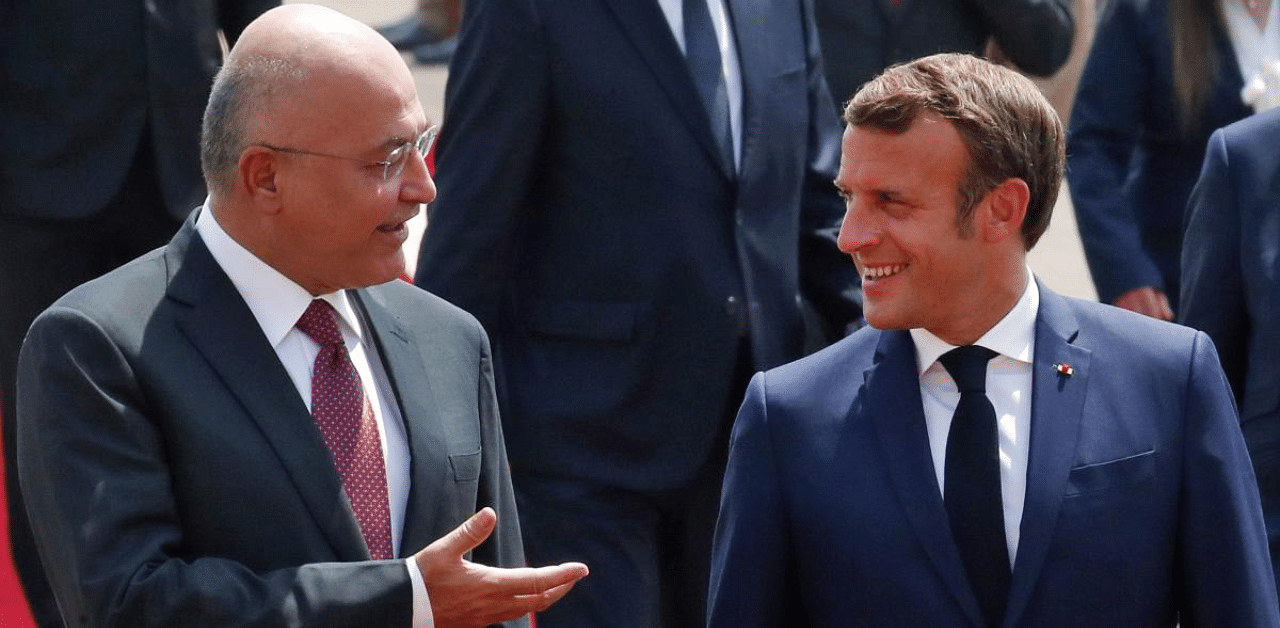 Iraqi President Barham Saleh (L) welcomes his French counterpart Emmanuel Macron as he arrives at the Salam Palace in Baghdad. Credit: AFP Photo