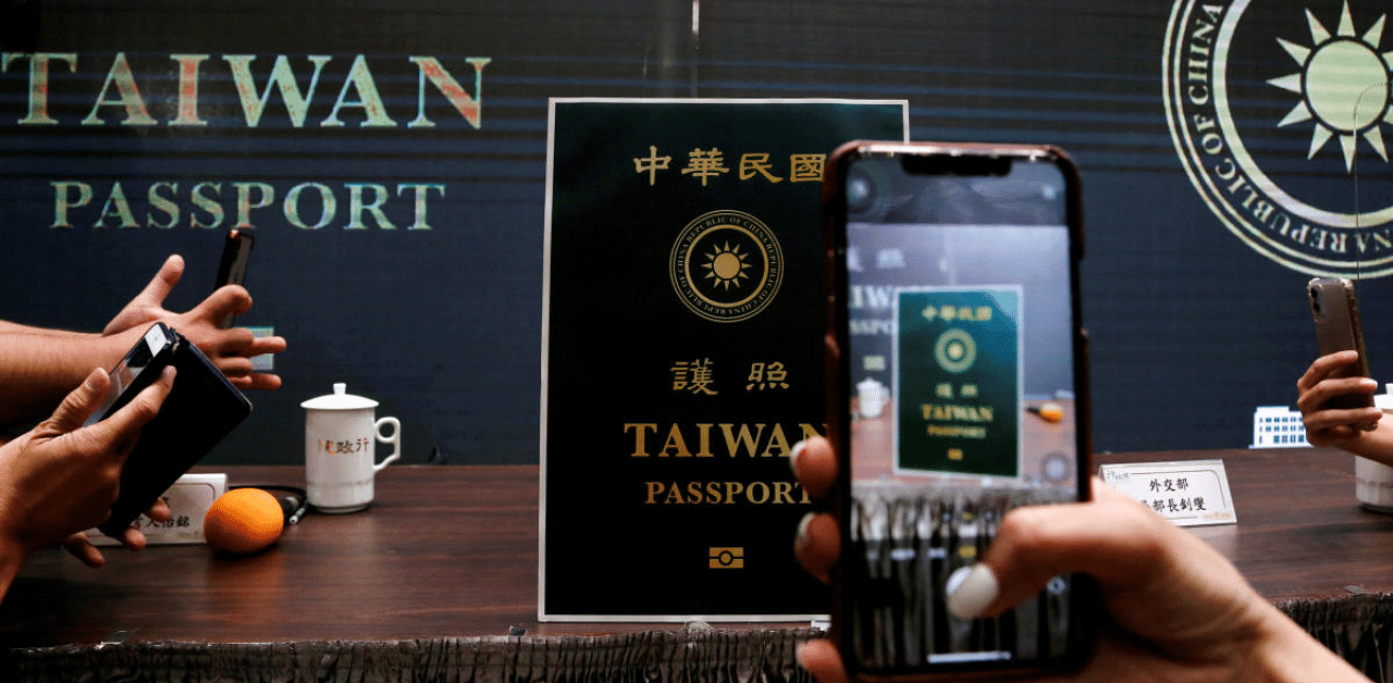 Members of the media take photos of a paper cut out of the new Taiwan passport displayed in Taipei, Taiwan. Credit: Reuters Photo