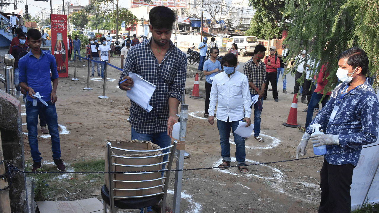 A student sanitizes his hands as he arrives to appear in JEE-2020 Main entrance exam, amid the ongoing coronavirus pandemic. Credits: PTI Photo