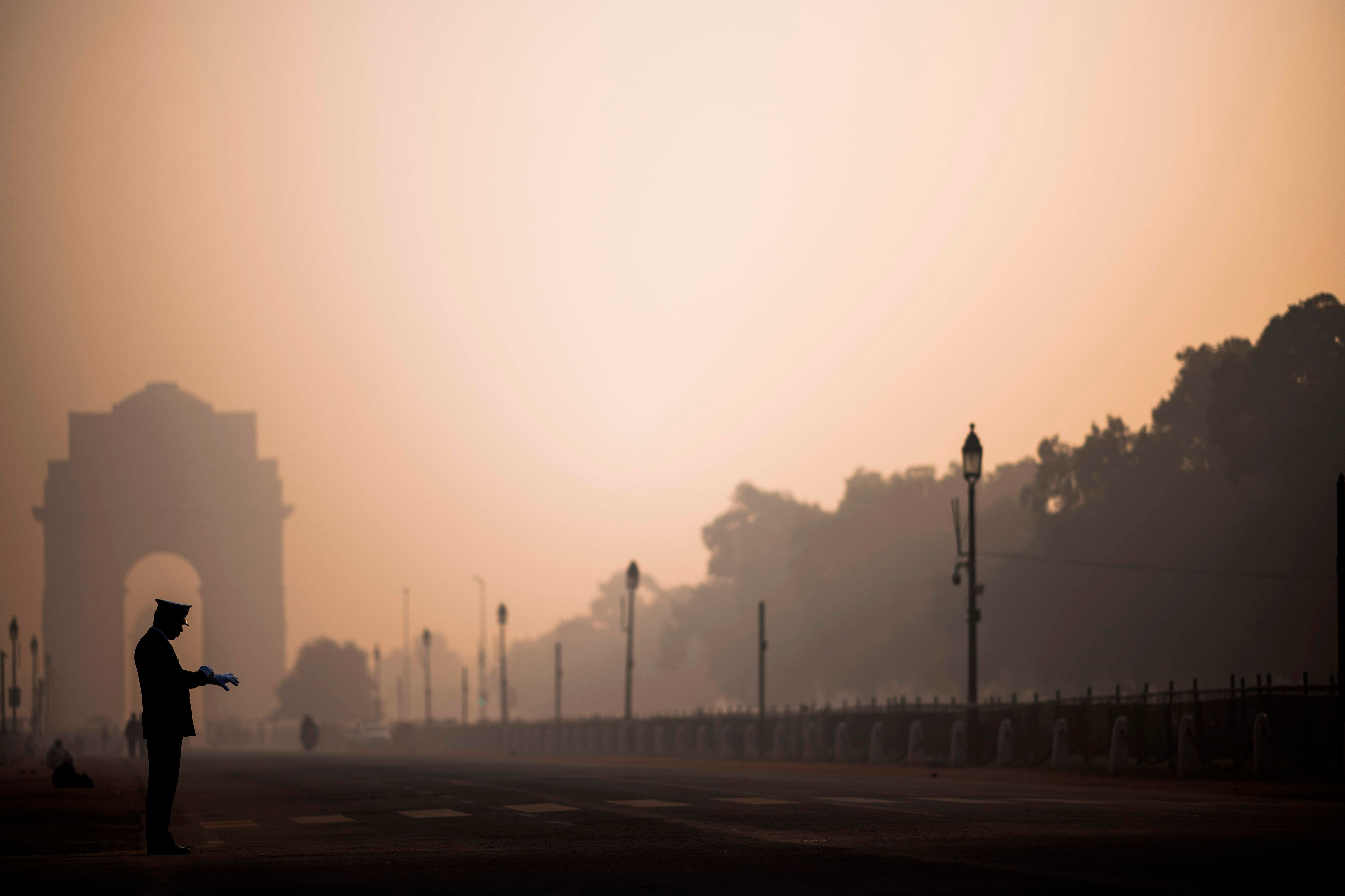 A soldier waits on a street near India Gate in heavy smoggy conditions in New Delhi. Credit: AFP
