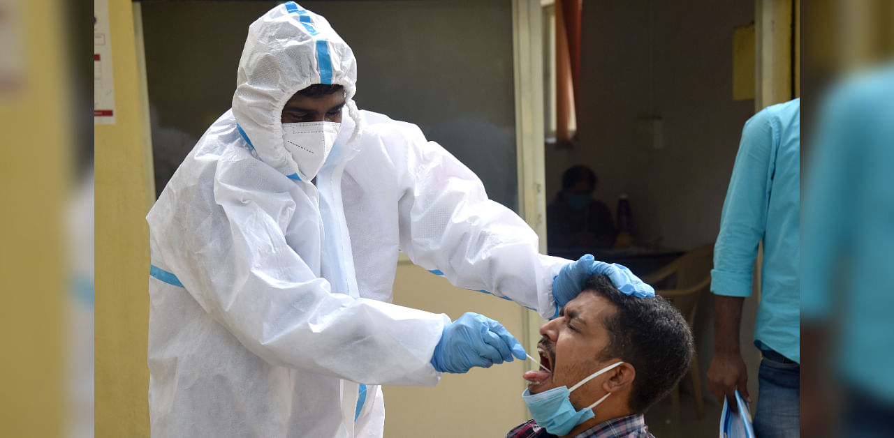 Health staff conducting coronavirus test amid Covid 19 lockdown's Unlock 4.0 relief free checkup by BBMP at Sajjan Rao circle in Bengaluru. Credit: DH Photo/S K Dinesh