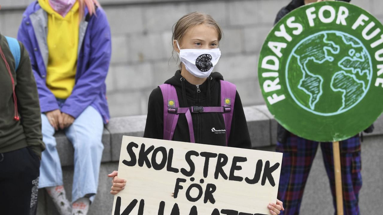 Swedish climate activist Greta Thunberg holds a poster reading "School strike for Climate" as she protests in front of the Swedish Parliament Riksdagen. Credit: AP/PTI