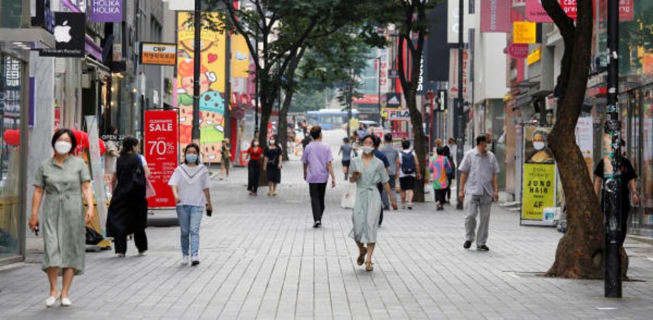 People wearing masks walk at Myeongdong shopping district, as social distancing measures were introduced to avoid the spread of the coronavirus disease. Credit: Reuters