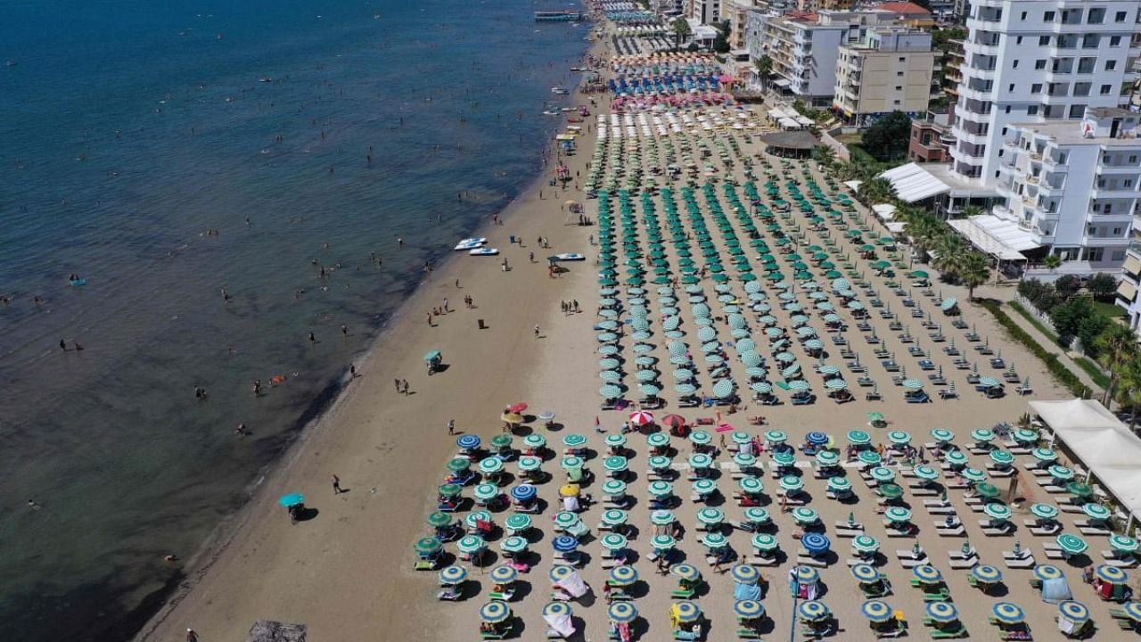 An aerial photograph taken on August 22, 2020, shows parasols on a beach of the Adriatic Sea in Durres, as a heatwave sweeps through Europe. - Due to the Covid 19 pandemic, the number of tourists entering Albania dropped by 66 percent. Credit: AFP