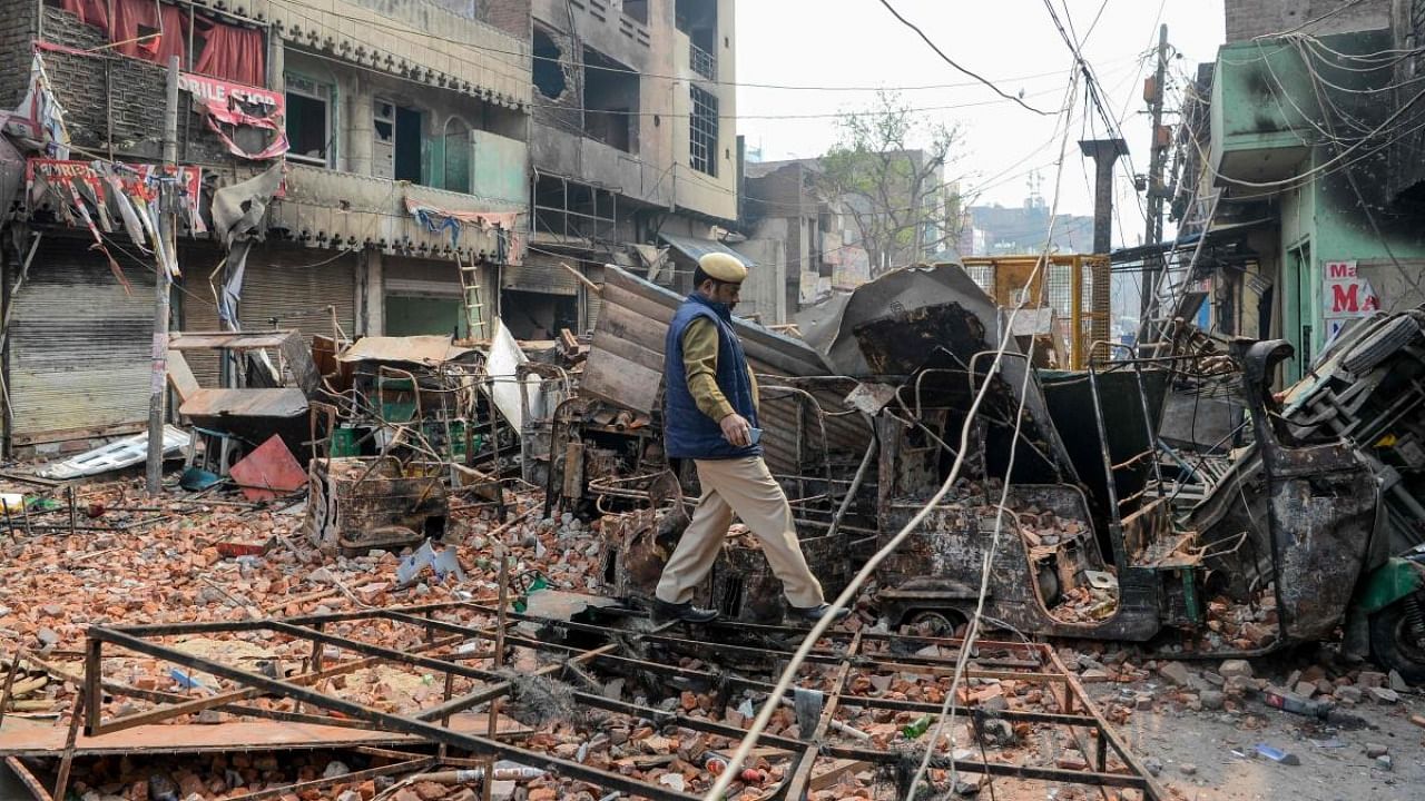 In this file photo taken on February 26, 2020, a security personnel patrols near burnt-out and damaged residential premises and shops following clashes between people supporting and opposing a contentious amendment to India's citizenship law. Credit: AFP