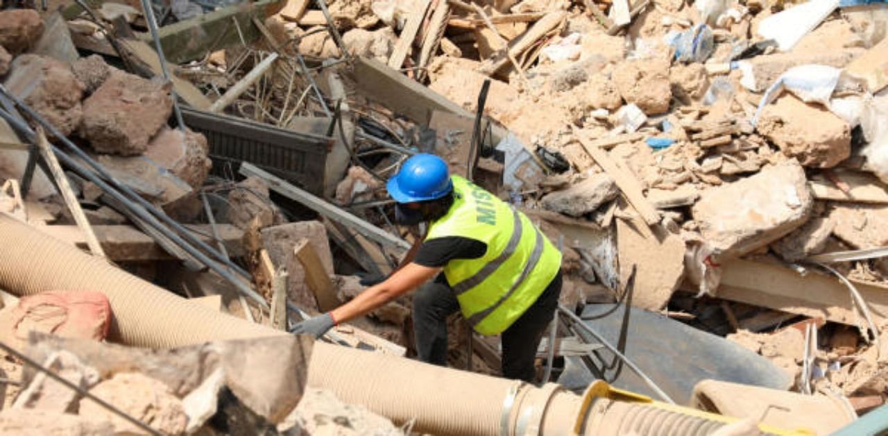 A volunteer digs through the rubble of buildings which collapsed due to the explosion at the port area, after signs of life were detected, in Gemmayze, Beirut. Credit: Reuters