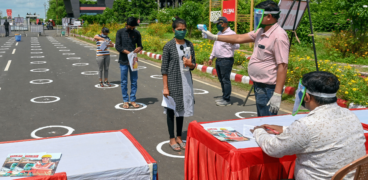 Students undergo thermal scanning outside an examination centre as they arrive to appear in the JEE Main entrance exam amid Covid-19 pandemic, in Jabalpur. Credit: PTI Photo