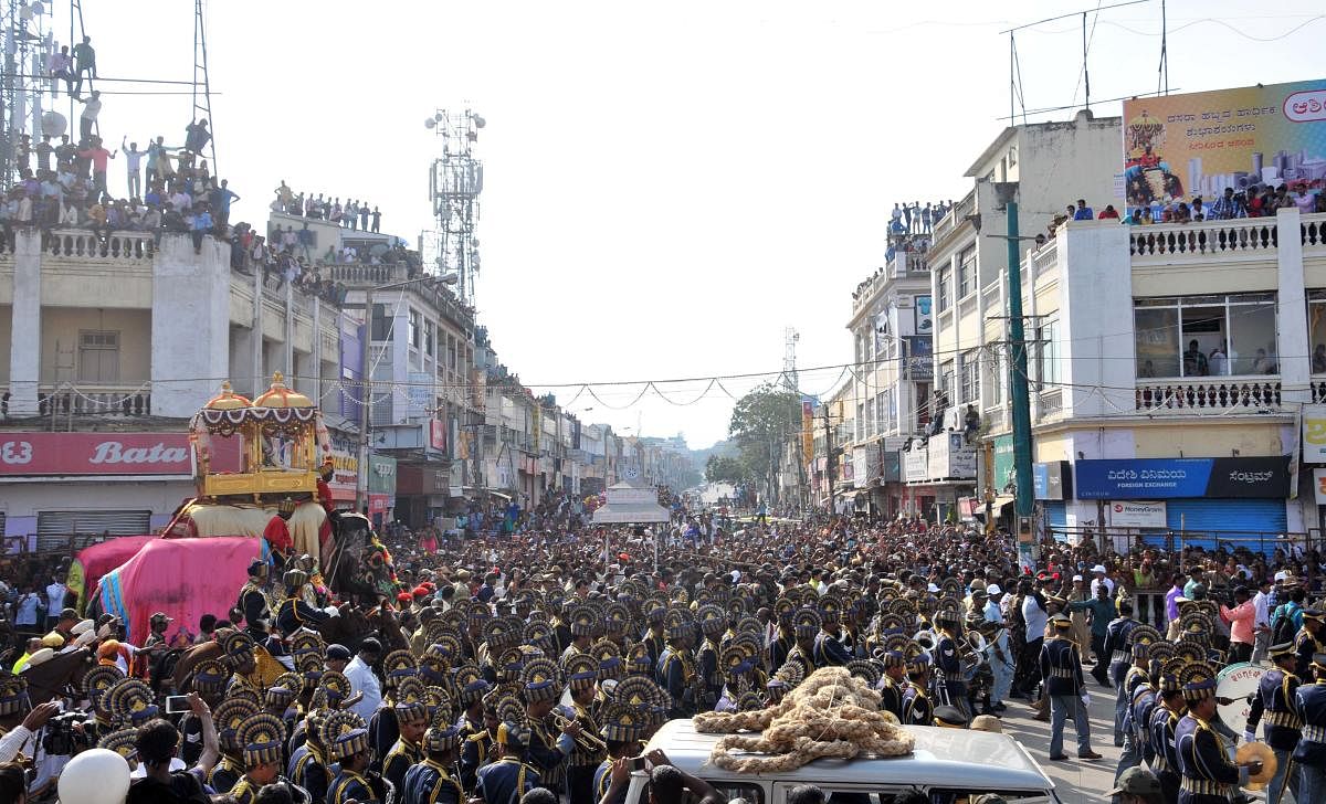 People watch Jamboo Savari as part of Mysuru Dasara at KR Circle, with D Devaraja Urs Road in the background.
