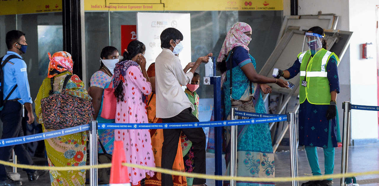 Passengers get their temperature checked as they arrive at a metro station following the resumption of train services, in Hyderabad. Credit: AFP Photo