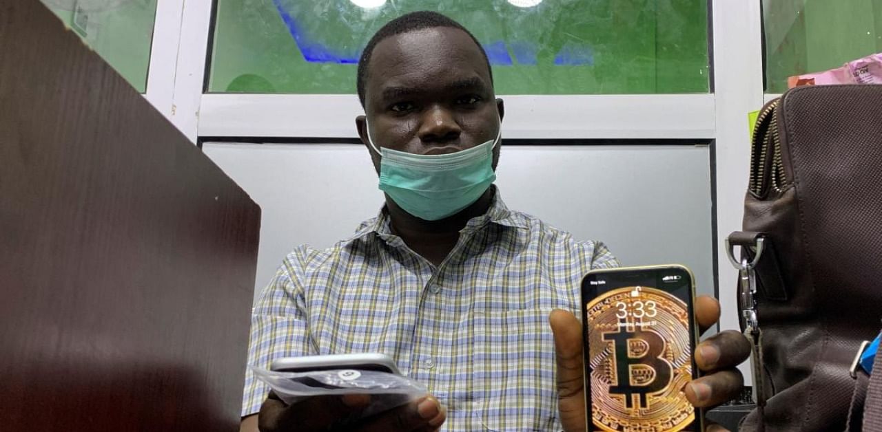 Abolaji Odunjo, a gadget vendor who trades with bitcoin, poses with his mobile phone. Credit: Reuters
