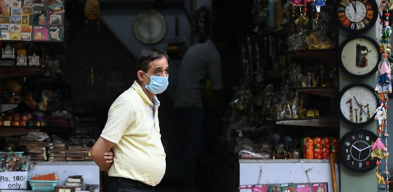 A shopkeeper wearing a facemask, waits for customers in a market in New Delhi. Credit: AFP
