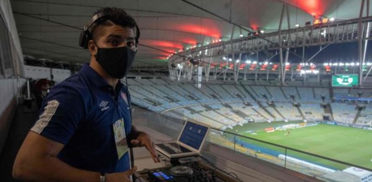 Fluminense DJ Franklin Scheleger, 29, plays sounds and songs miming a crowded stadium, during the Brazilian Championship match between Fluminense and Atletico Goianiense at the Maracana stadium in Rio de Janeiro, Brazil. Credit: AFP