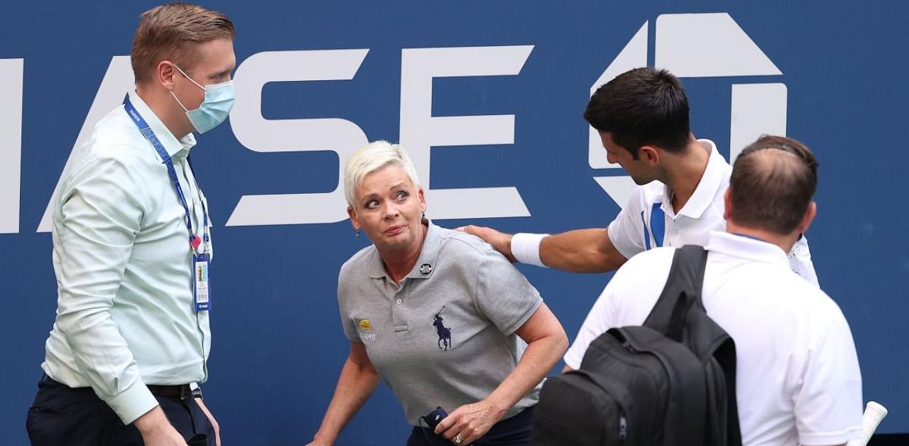 Novak Djokovic of Serbia tends to a lineswoman after accidentally striking her with a ball hit in frustration. Credit: AFP Photo