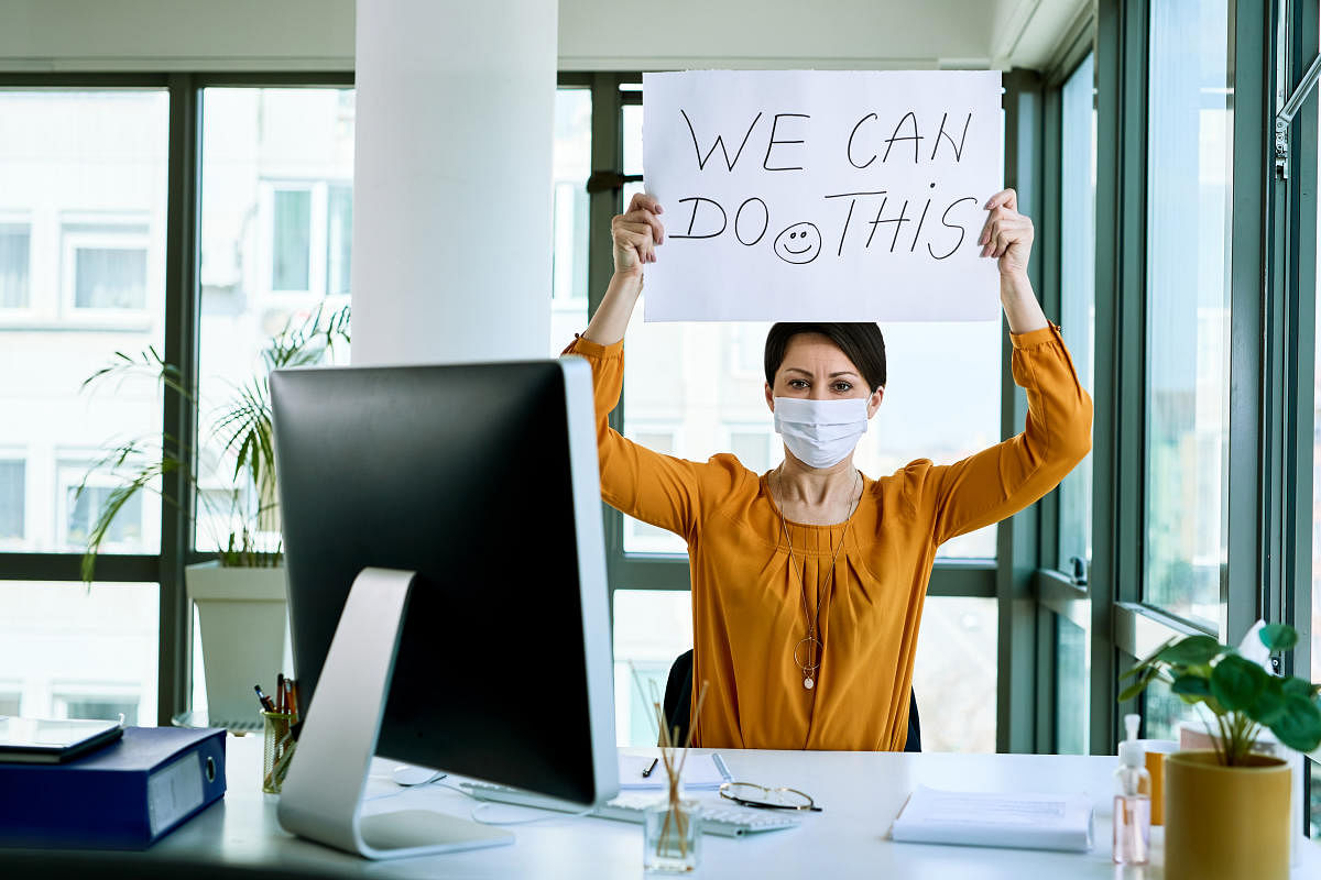 Businesswoman holding placard with we can do this text as support during virus epidemic.Upskilling and career change are two options trending among young professionals