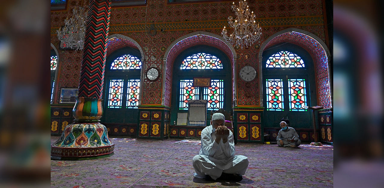 Muslim devotees wearing facemasks pray inside the Sheikh Abdul Qadir Geelani shrine in downtown Srinagar/ Representation. Credit: AFP