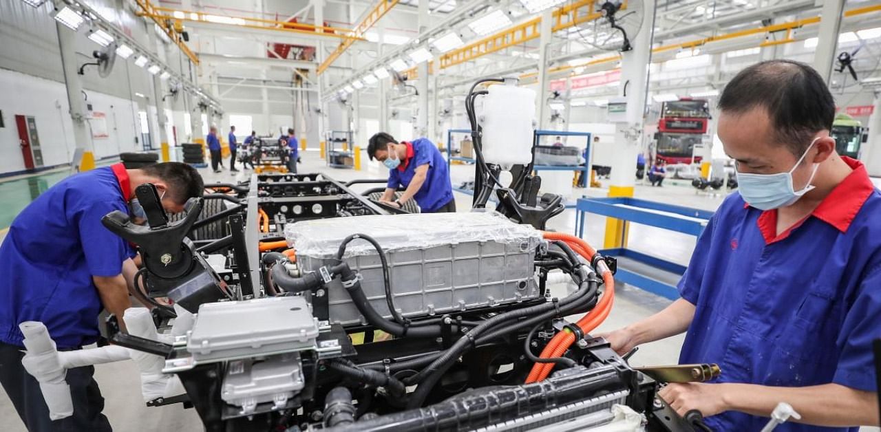 Employees working on a new energy vehicle (NEV) assembly line at a BYD Auto factory in Huaian in China's eastern Jiangsu province. Credit: AFP