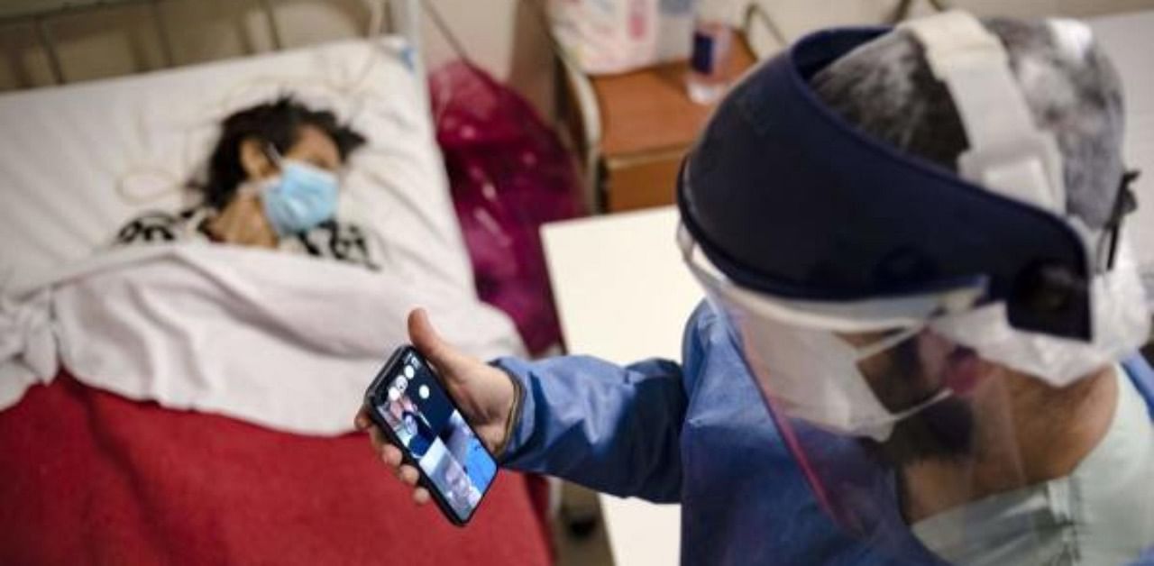 Dr Mario Grossmann holds a video call with his students of Semiology during his 24hs shift, at the emergency area of the Doctor Alberto Antranik Eurnekian Public Hospital in Ezeiza. Credit: AFP Photo