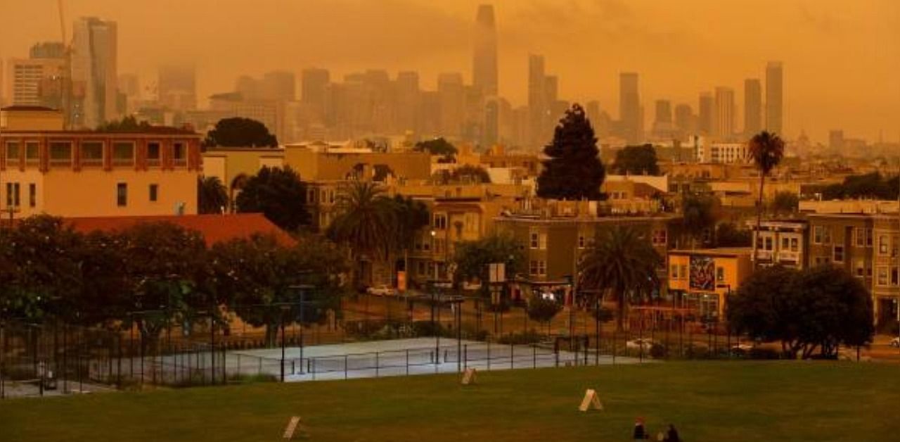 People relax under an orange smoke-filled sky at Dolores Park in San Francisco, California. Credit: AFP Photo