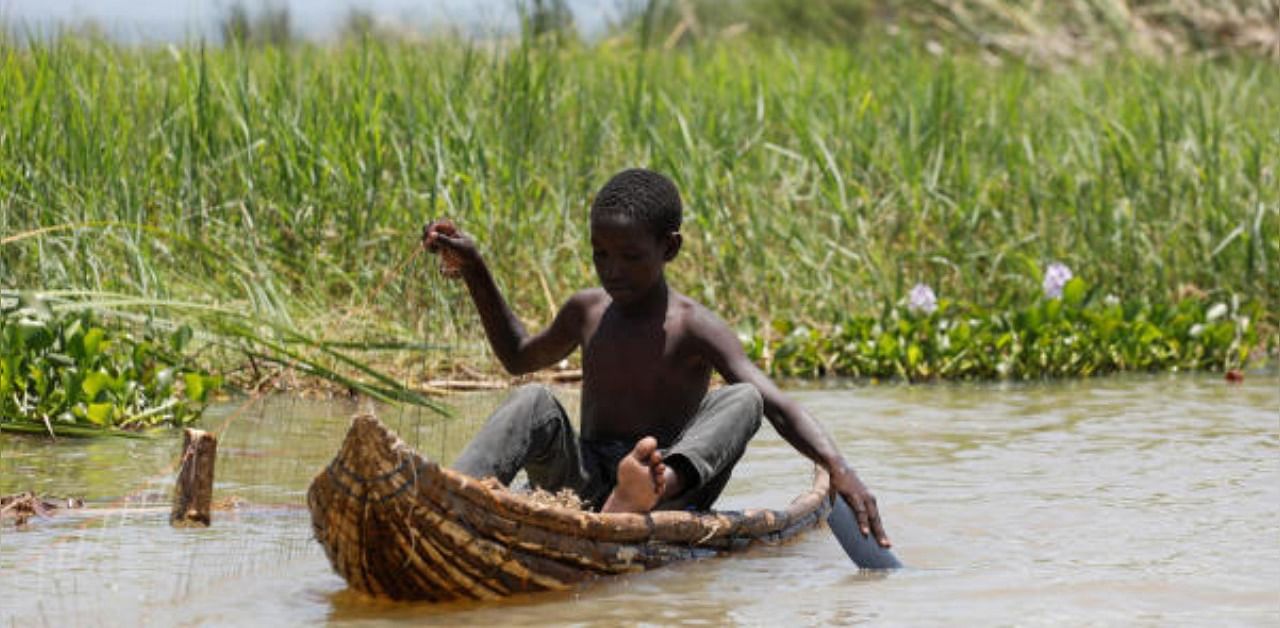 A boy uses a makeshift boat to fish in the water rising due to months of unusually heavy rains in lake Baringo, Kenya. Representative Photo. Credit: Reuters