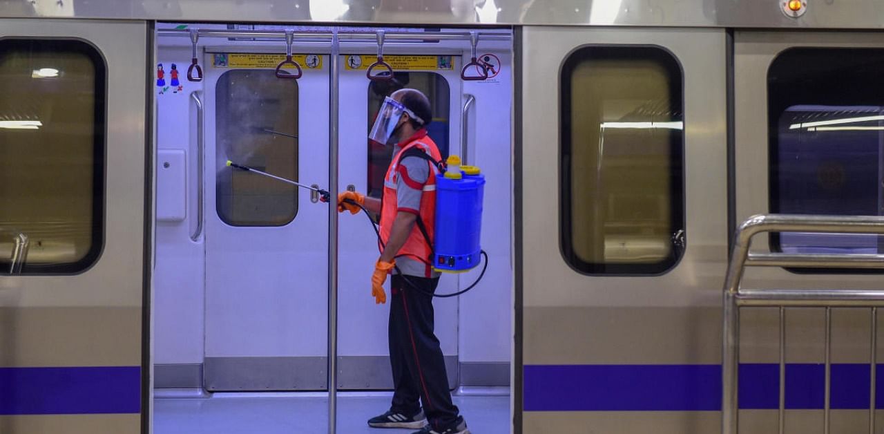 A worker sanitizes a metro train at Kashmere Gate Metro Station after the metro services resumed. Credit: PTI