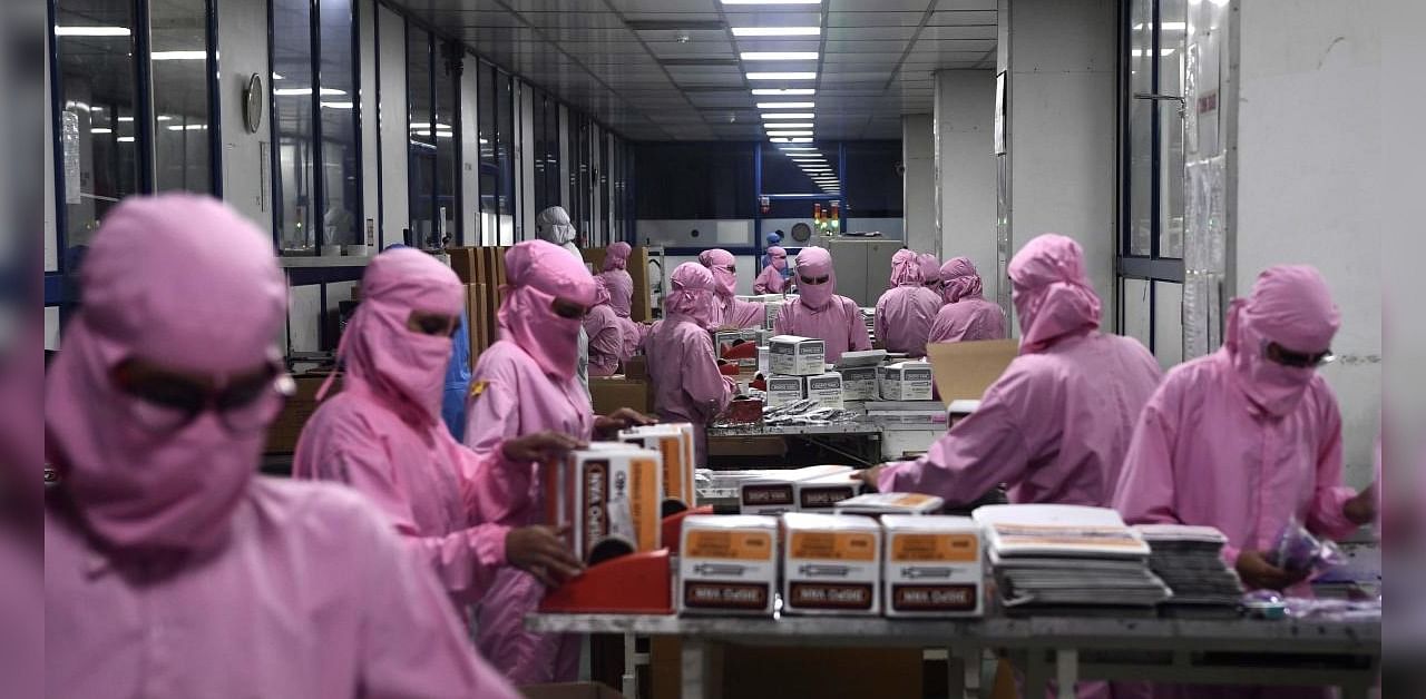 In this photograph taken on September 2, 2020, workers pack syringes at the Hindustan Syringes factory in Faridabad. Credit: AFP Photo
