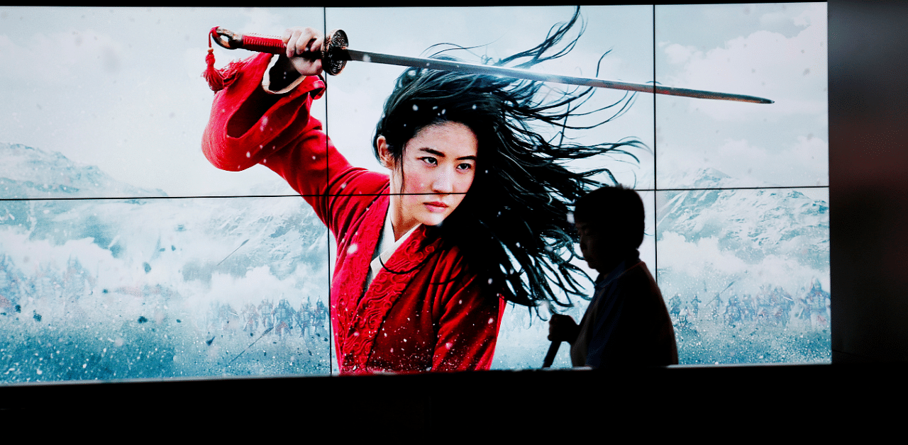 A cleaner walks past screens promoting Disney's movie 'Mulan' as the film opens in China, at a cinema in Beijing, China. Credit: Reuters Photo