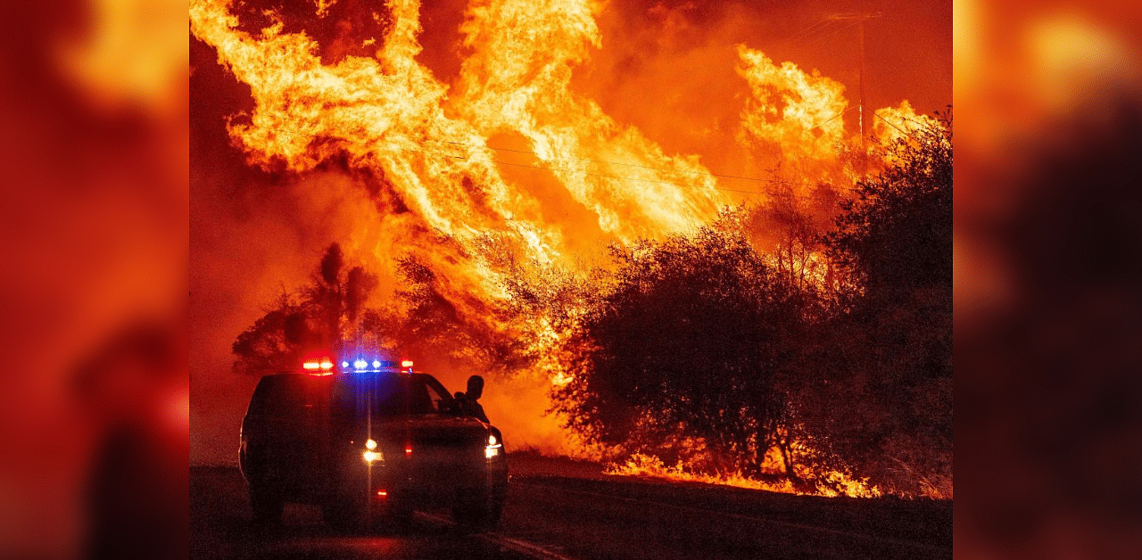 A law enforcement officer watches flames launch into the air as fire continues to spread during the Bear fire in Oroville, California on September 9, 2020. Credit: AFP Photo