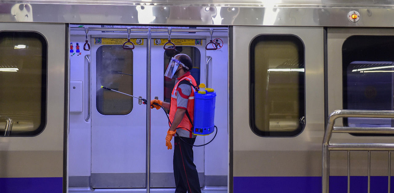 A worker sanitizes a metro train at Kashmere Gate Metro Station after the metro services resumed on Red, Green and Violet line from today with certain restrictions, in New Delhi. Credit: PTI Photo