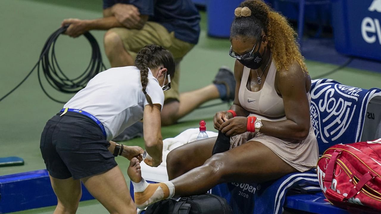 Serena Williams, of the United States, has her ankle taped by a trainer during a medical timeout during a semifinal match of the US Open tennis championships against Victoria Azarenka, of Belarus. Credit: AP/PTI