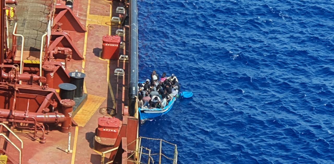 Migrants sit in a boat alongside the Maersk Etienne tanker off the coast of Malta. Credit:  Reuters Photo
