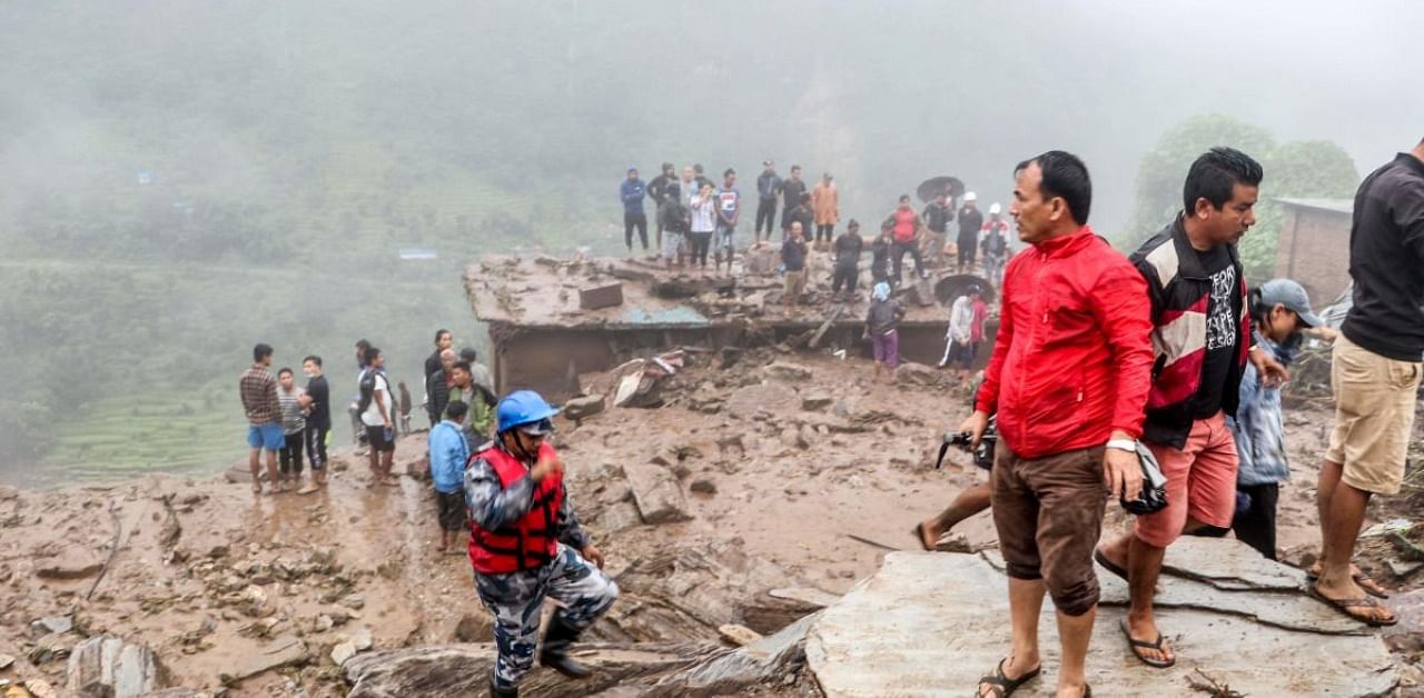 Rescue workers and residents gather for search at the scene of a landslide following heavy rains in Bahrabise municipality of Sindhupalchok district, some 90 kms northeast of Kathmandu. Credit: AFP