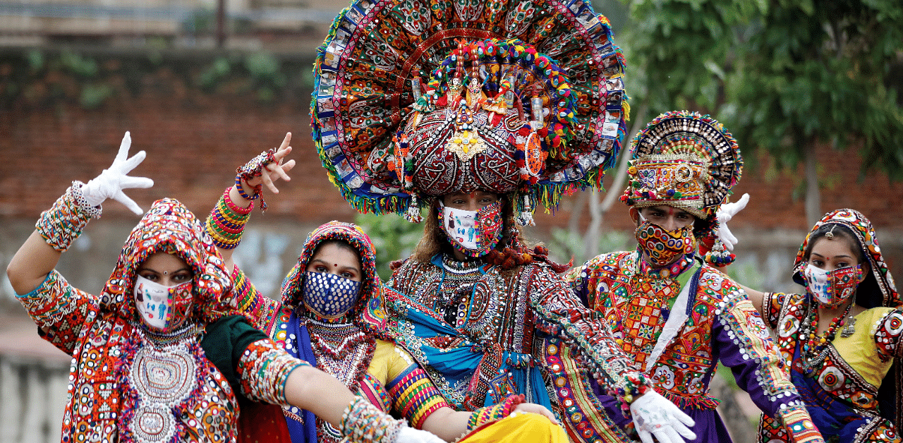 Participants in traditional costumes wearing face masks pose for a picture during rehearsals for Garba amid Covid-19. Credit: Reuters Photo
