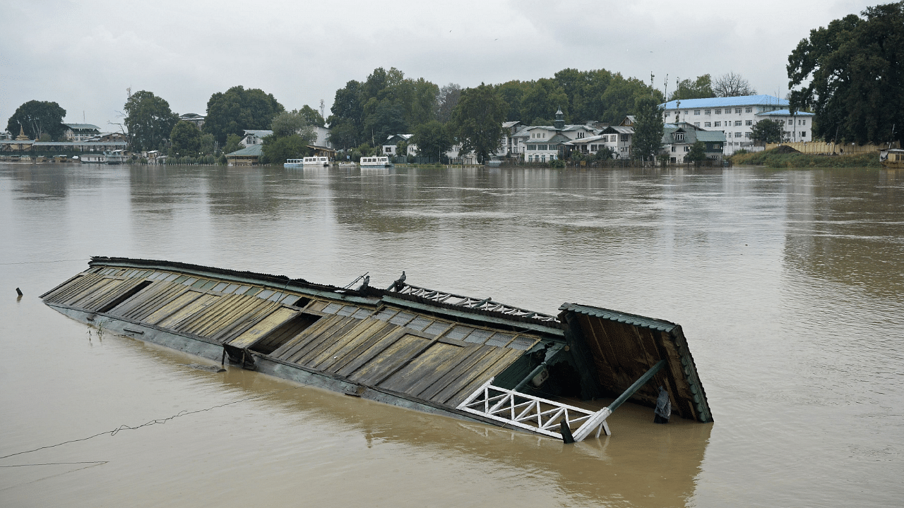 A partially submerged houseboat is seen in Jhelum river after heavy rain in Srinagar. Credits: AFP File Photo