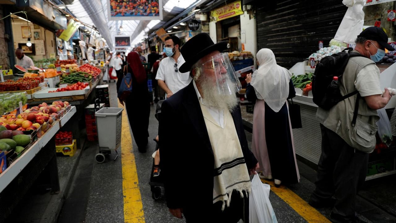 People wear face masks as they shop in a main market in Jerusalem. Representative image. Credit: Reuters/file