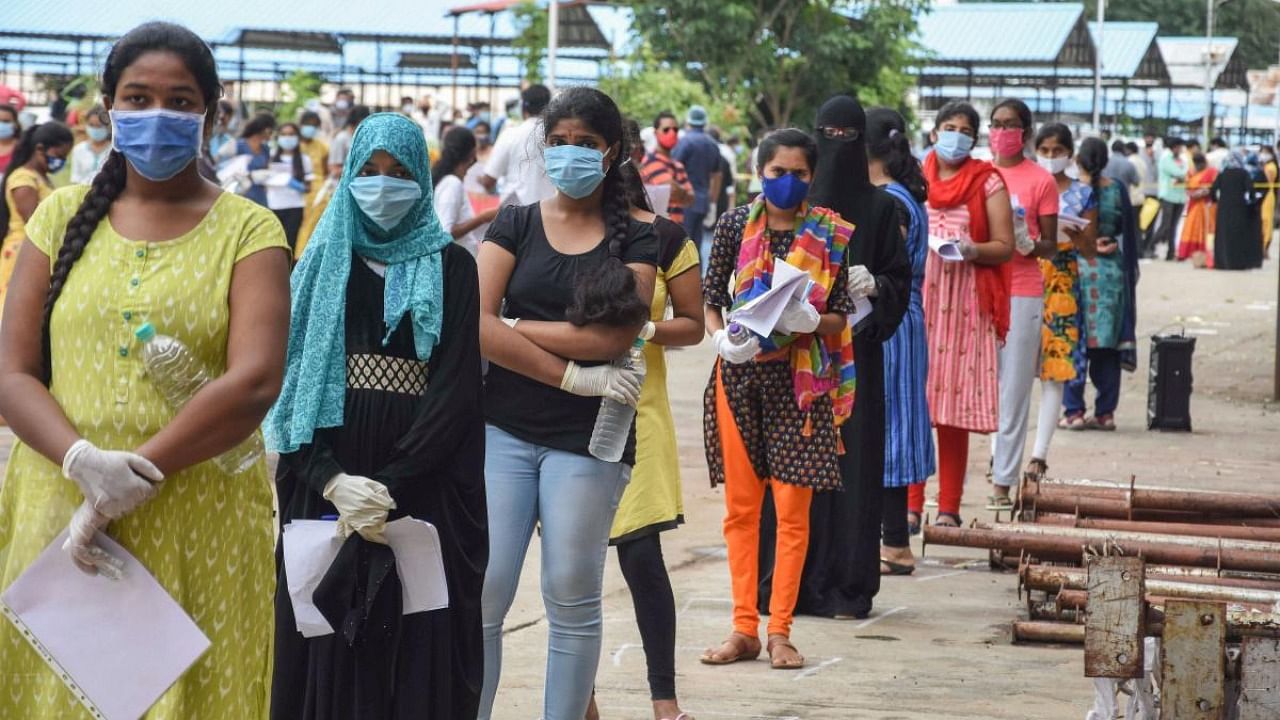 Students wait for thermal screening before entering a NEET eamination centre, amid the ongoing coronavirus pandemic, in Hyderabad. Credit: PTI