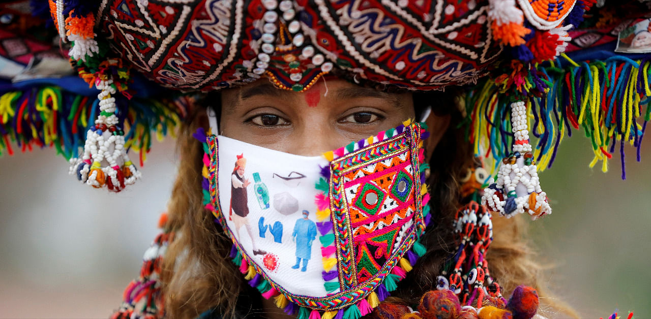 A participant in a traditional costume wearing a face mask attends a rehearsal for Garba, a folk dance, ahead of Navratri, Ahmedabad. Credit: Reuters