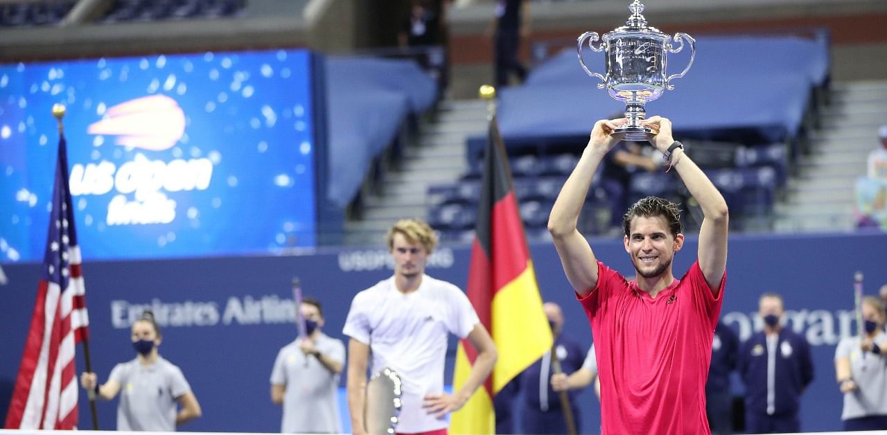 Dominic Thiem (R) of Austria celebrates with championship trophy after winning in a tie-breaker during his Men's Singles final match against Alexander Zverev (L) of Germany on Day Fourteen of the 2020 US Open. Credit: AFP Photo