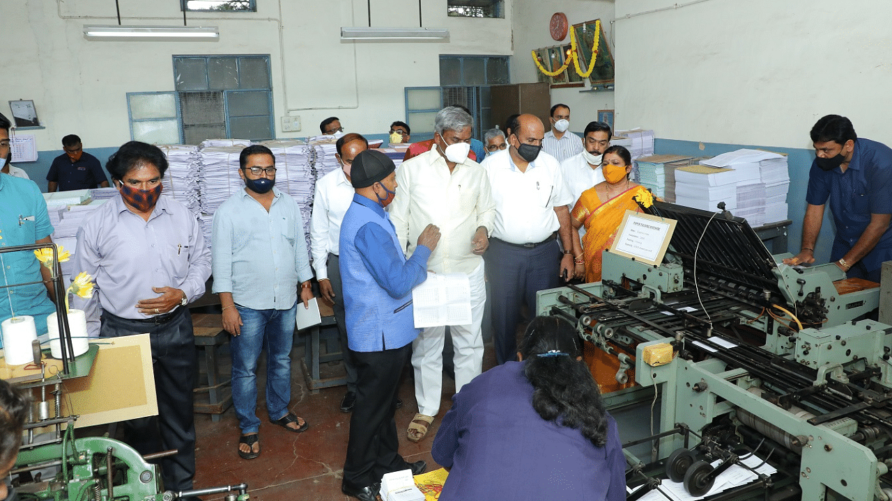 KSRTC Chairman M Chandrappa checks the new machines at the Karnataka State Transport Press, Bengaluru. Credits: DH Photo